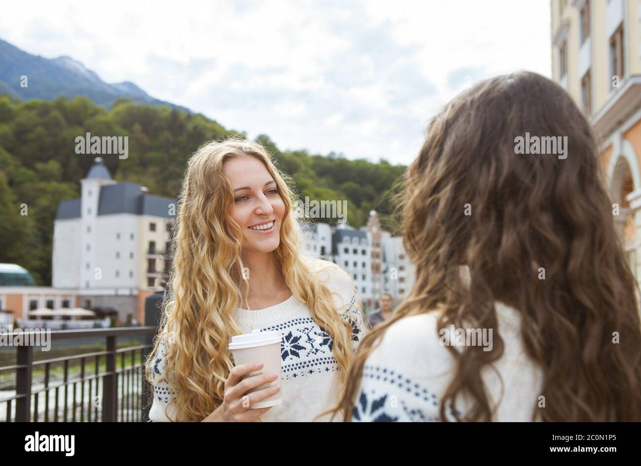 Zwei fröhliche Frauen, die sich in der Stadt unterhalten Stockfoto