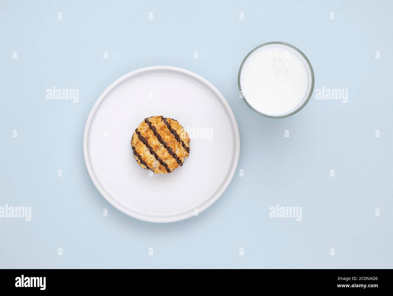 Kokosnusskekse und ein Glas milchfreie Milch auf hellblauem Hintergrund Stockfoto