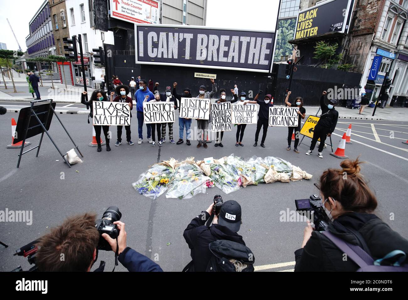 Aktivisten bei der Enthüllung einer Black Lives Matter UK (BLMUK) Plakatwand an der Westminster Bridge Road, London, In diesem Verzeichnis sind mehr als 3000 Namen von Personen aufgeführt, die in Polizeigewahrsam, Gefängnissen, Einwanderungsgefängnissen und bei rassistischen Angriffen im Vereinigten Königreich gestorben sind, sowie von Personen, die an den Folgen des Coronavirus gestorben sind. Die Plakatwand wurde von BLMUK in Zusammenarbeit mit der United Families and Friends Campaign, Justice for Belly, Justice for Shukri, Migrant Organize und dem Grenfell Estate errichtet. Stockfoto