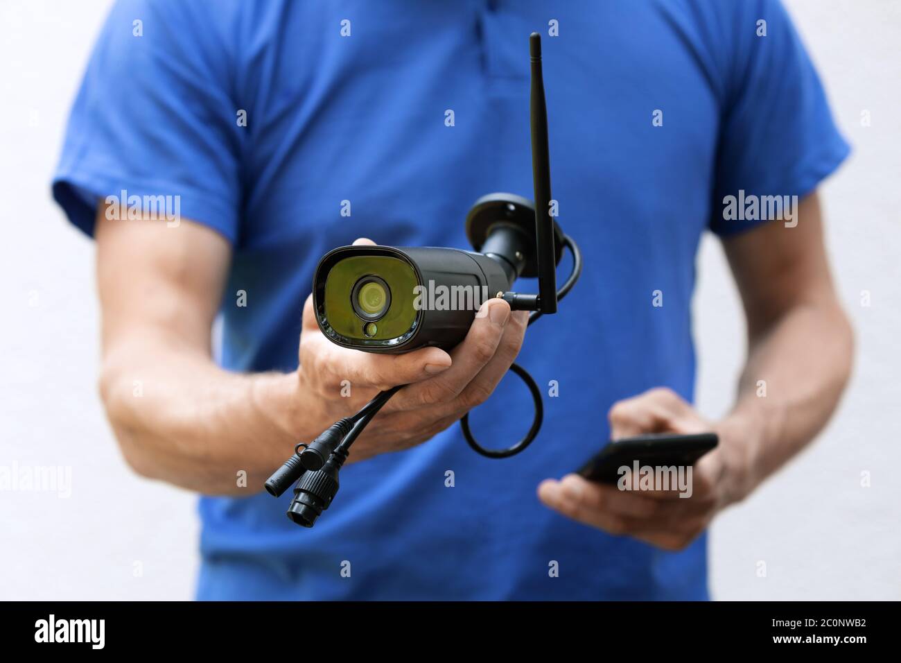 Überwachungskameras und cctv-Dienste - Techniker mit ip-Kamera in der Hand Stockfoto