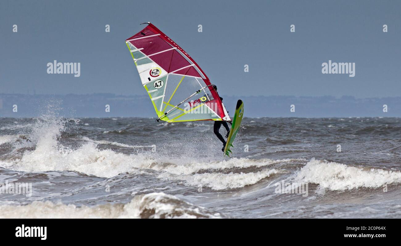 Portobello, Edinburgh, Schottland, Großbritannien. Juni 2020. Ungewöhnlich guter Wind in die richtige Richtung für zwei Windsurfer direkt vor Portobello am Firth of Forth, Wind aus Osten 25km/h mit möglichen Böen von 47 km/h mit hellen Intervallen. Die beiden Jungs Jake und Tom waren seit 5 Uhr morgens an der Ostküste auf der Suche nach den richtigen Bedingungen, dies war die letzte halbe Stunde vor dem Heimweg. Stockfoto