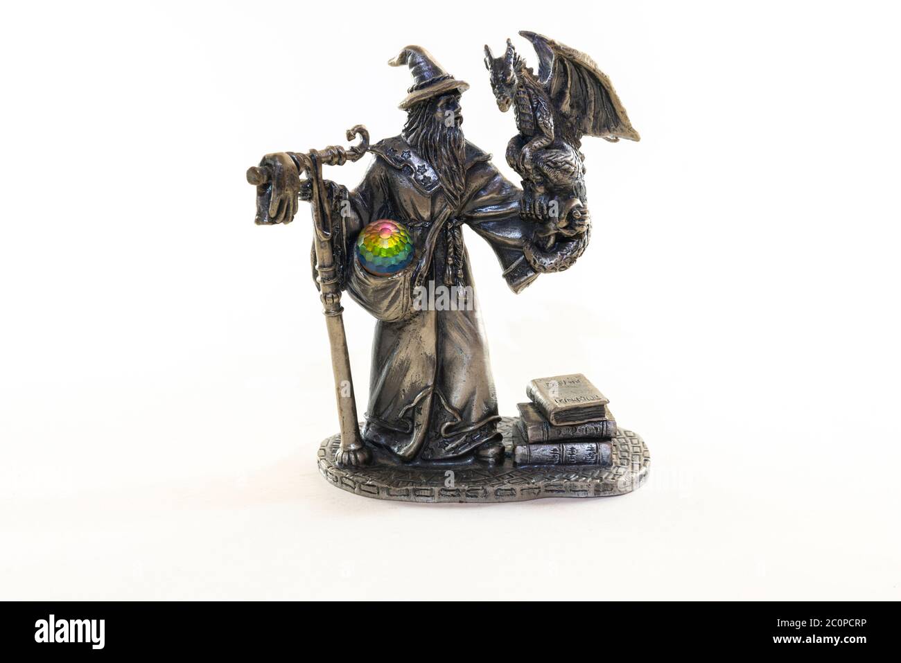 Athen, Attika / Griechenland. Metallische Figur eines Zauberers, der einen kleinen geflügelten Drachen auf der Hand hält. Kristallkugel in seiner Tasche und Bücher von withcraft Stockfoto