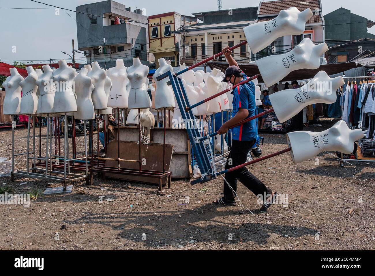 Jakarta, Indonesien. Juni 2020. Ein Straßenhändler sah auf dem Tasik-Markt in Jakarta, Indonesien, eine Puppe als vorbeugende Maßnahme tragen, während er eine Gesichtsmaske trug, 11. Juni 2020. Einige Händler haben ihren Stand in Jakarta wieder geöffnet, während einige ihre Geschäfte wegen des Dilemmas inmitten der Coronavirus-Ängste geschlossen hielten. Früher gab die Regierung ihnen die Erlaubnis, die Einkaufszentren und Märkte offen zu halten, um eine soziale Distanzierung, strikte Gesundheits- und Sicherheitsprotokolle zu implementieren. (Foto: Evan Praditya/INA Photo Agency/Sipa USA) Quelle: SIPA USA/Alamy Live News Stockfoto