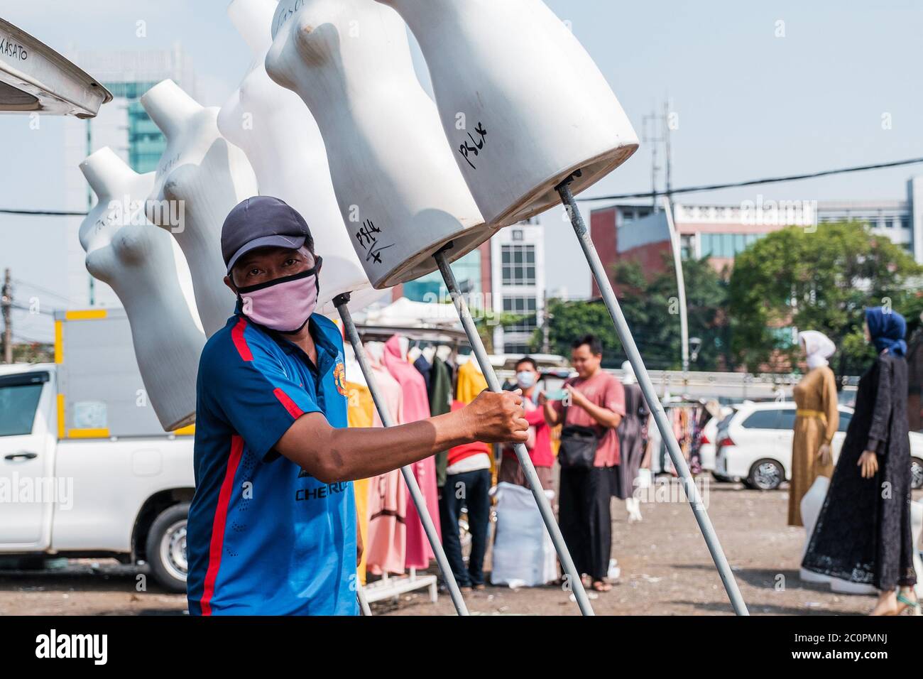 Jakarta, Indonesien. Juni 2020. Ein Straßenhändler sah auf dem Tasik-Markt in Jakarta, Indonesien, eine Puppe als vorbeugende Maßnahme tragen, während er eine Gesichtsmaske trug, 11. Juni 2020. Einige Händler haben ihren Stand in Jakarta wieder geöffnet, während einige ihre Geschäfte wegen des Dilemmas inmitten der Coronavirus-Ängste geschlossen hielten. Früher gab die Regierung ihnen die Erlaubnis, die Einkaufszentren und Märkte offen zu halten, um eine soziale Distanzierung, strikte Gesundheits- und Sicherheitsprotokolle zu implementieren. (Foto: Evan Praditya/INA Photo Agency/Sipa USA) Quelle: SIPA USA/Alamy Live News Stockfoto