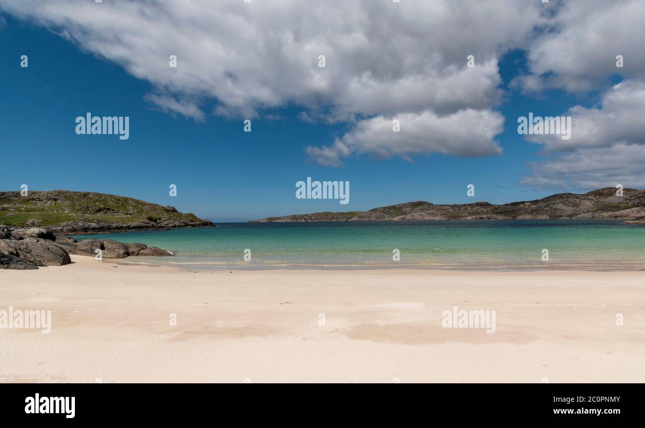 ACHMELVICH BAY UND STRAND SUTHERLAND HIGHLANDS SCHOTTLAND EIN BLAUER HIMMEL DER WEISSE SAND UND DIE FARBEN DES MEERES Stockfoto