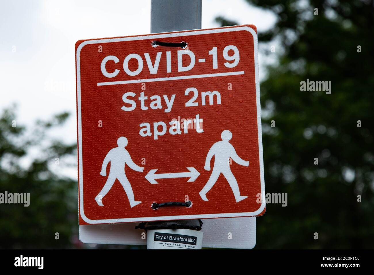 Covid-19 Schilder in Baildon, Yorkshire, warnen die Menschen zu Fuß 2 Meter auseinander. Stockfoto