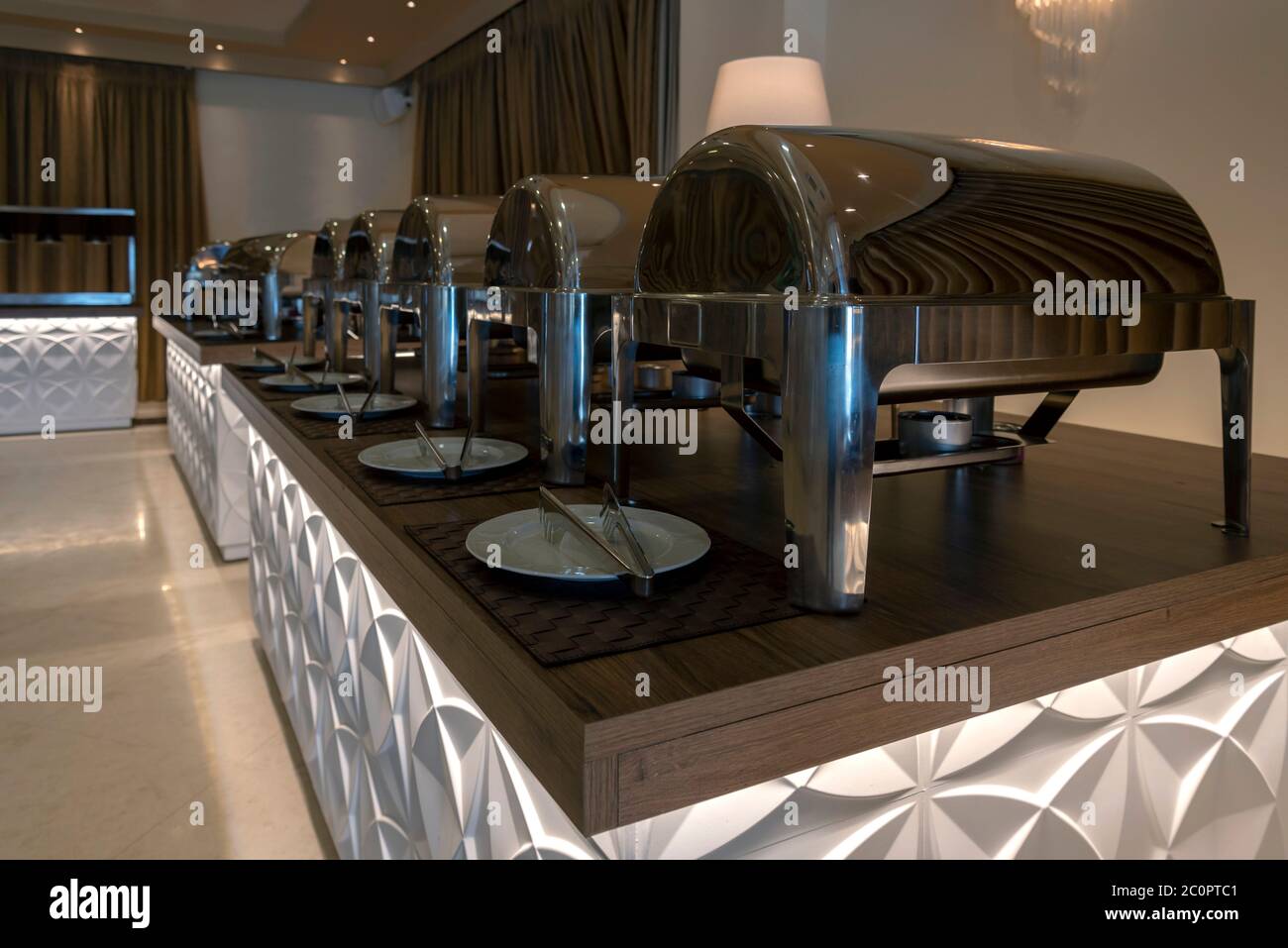 Innenansicht eines Cateringraums Buffet-Party bereit, um Menschen für eine Hochzeit oder Feier zu begrüßen. Scheufschale. Teller und Küchenzange Stockfoto