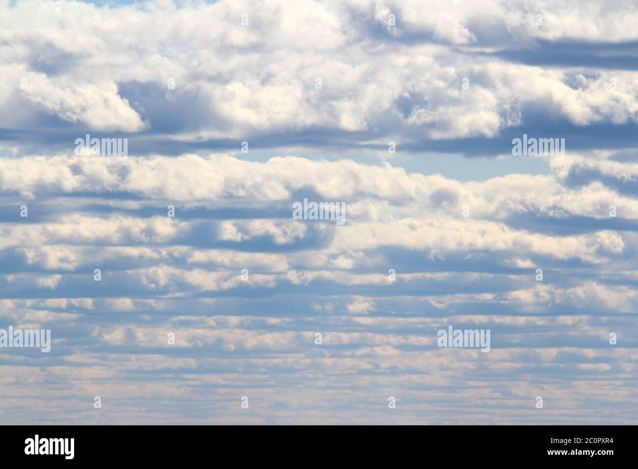 Weiße flauschige Wolken auf einem Hintergrund von blauem Himmel im Sommer. Das Konzept von Wetter und Klima. Stockfoto