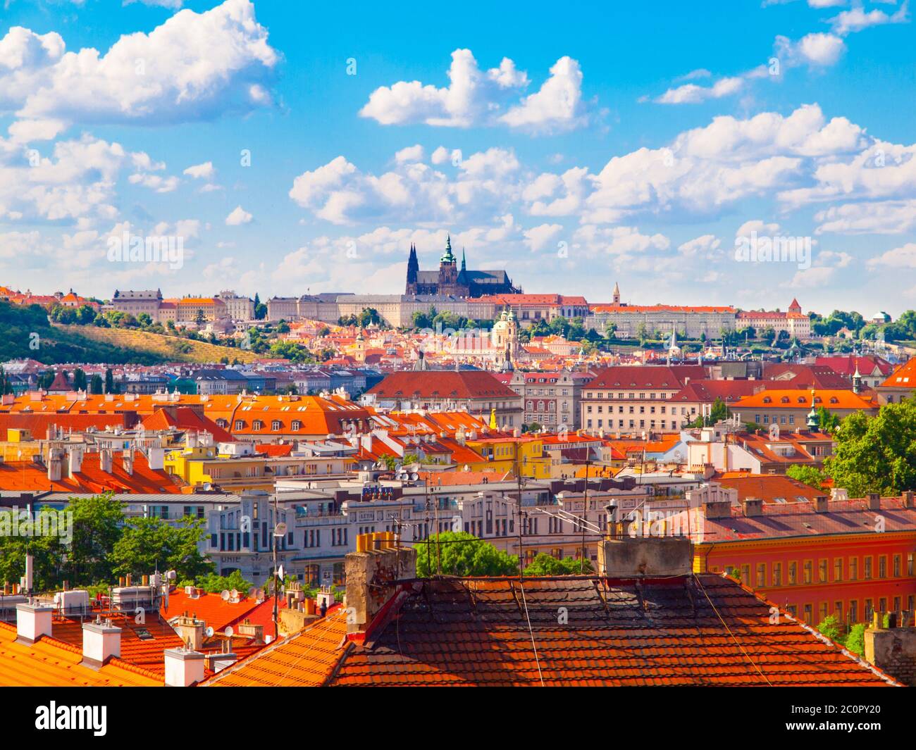 Prag Panorama mit Prager Burg - Hradcany und roten Dächern. Sonniger Sommertag mit blauem Himmel und weißen Wolken, Tschechische Republik. Stockfoto