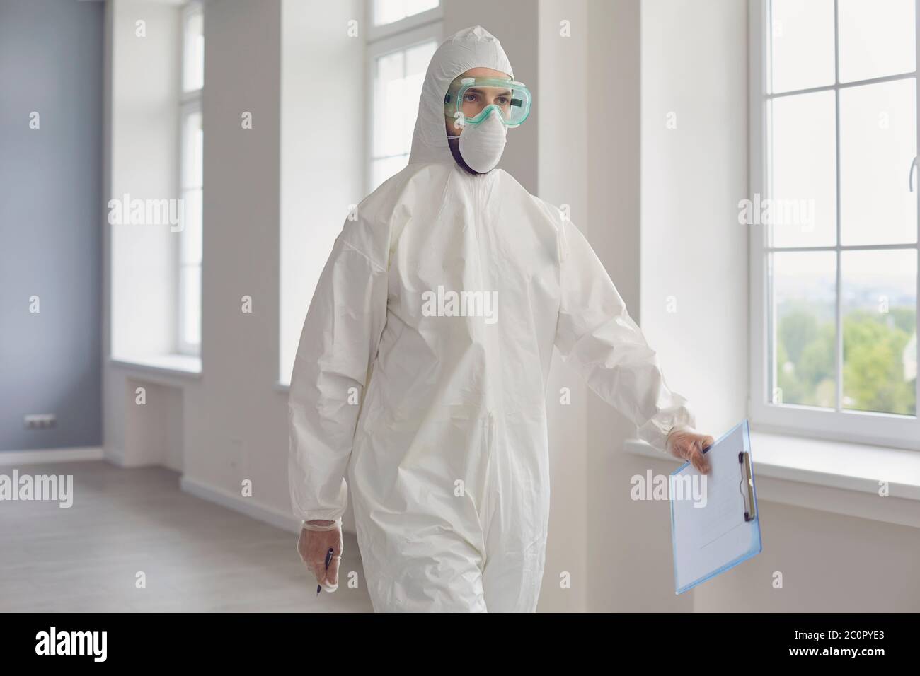 Arzt in Schutzkleidung zu Fuß entlang Krankenhaus Halle. Medic in Hazmat Anzug Kampf mit ansteckenden Krankheiten in der Klinik Stockfoto
