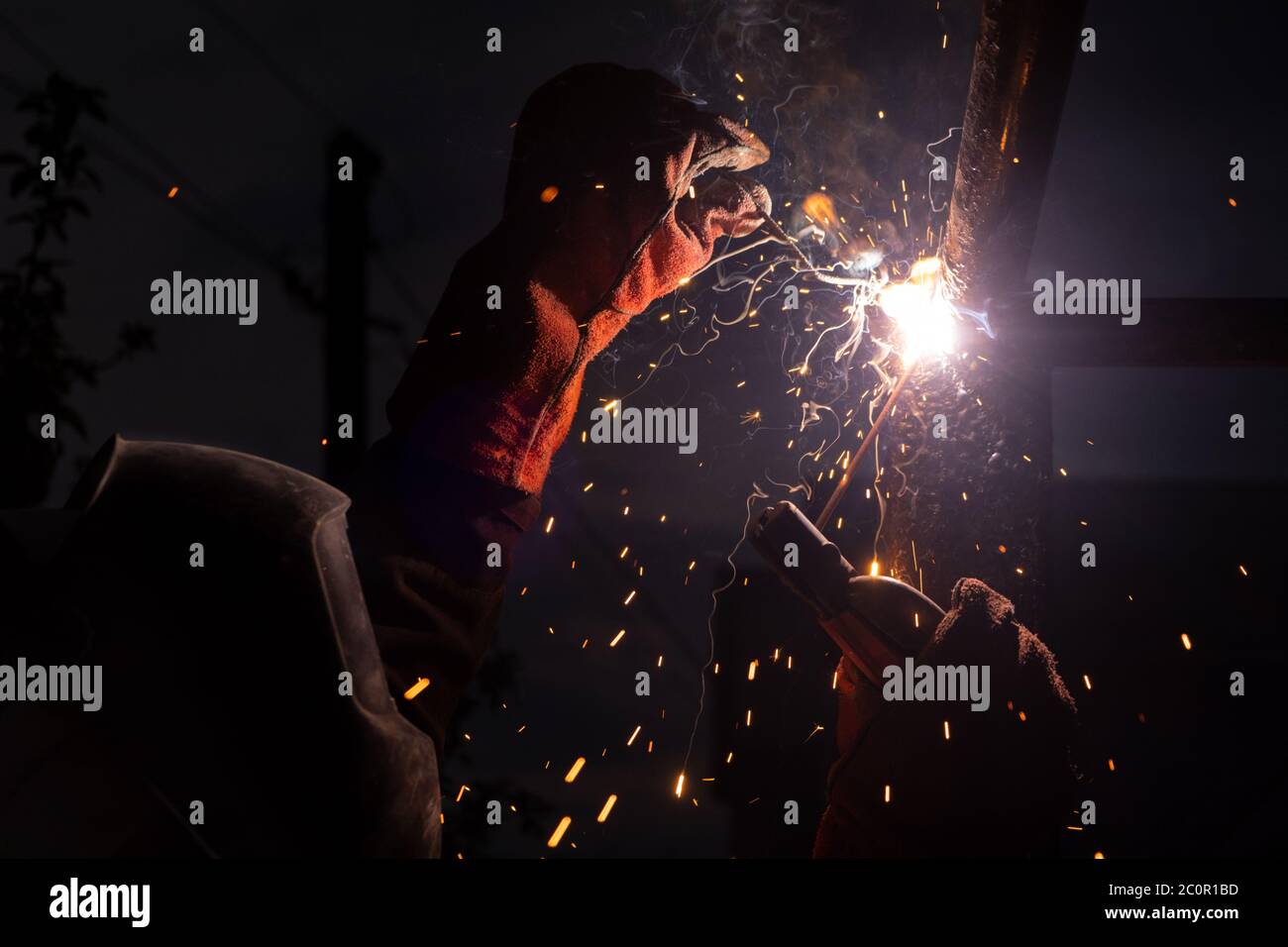 Schweißen von Stahl mit Funken. Schweißen von Nahaufnahme. Schweißmaschine mit Schutzmaske Schweißmetall Stockfoto