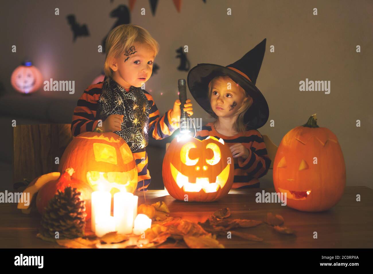 Liebenswert Kinder, Kleinkind Junge und Mädchen, spielen mit Halloween geschnitzten Kürbis und Dekoration zu Hause Stockfoto