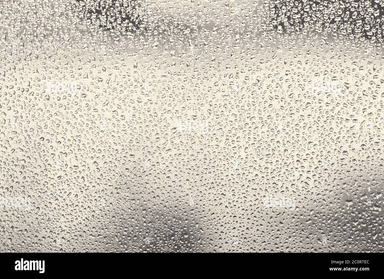 Wasser tropft auf Glas, viel Regen fällt auf das Fensterglas Stockfoto