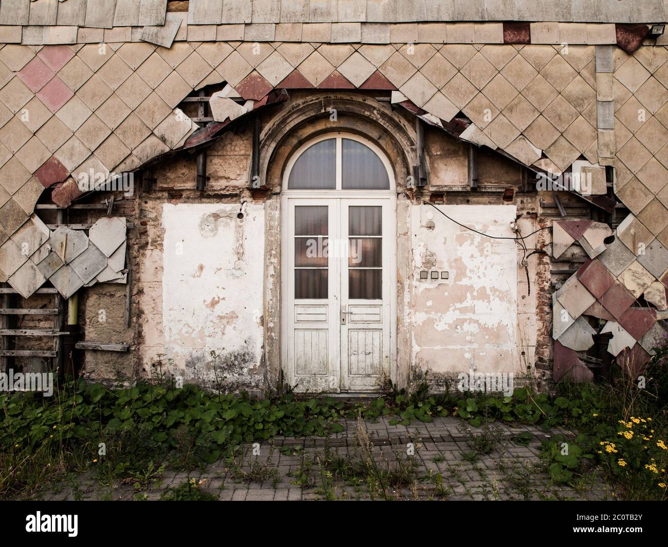 Verfallene Eingangstür zum alten zerstörten Gebäude. Vintage-Bild. Stockfoto