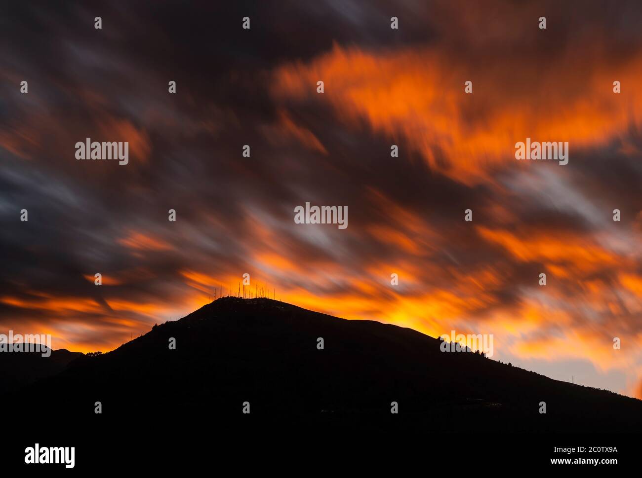 Langzeitbelichtung bei Sonnenuntergang des Pichincha Vulkans Silhouette, Quito, Ecuador. Stockfoto