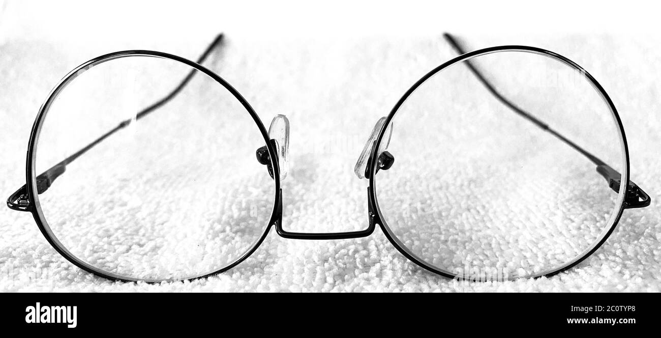 Brillen oder Brillen auf weißem Hintergrund. Schwarz-Weiß-Fotoeffekt auf einem runden Brillenrahmen hinzugefügt. Runder oder ovaler Glasrahmen Stockfoto