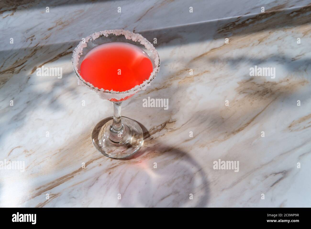 Rosa martini mit gesalzenem Rand auf Marmor-Küchentisch Stockfoto