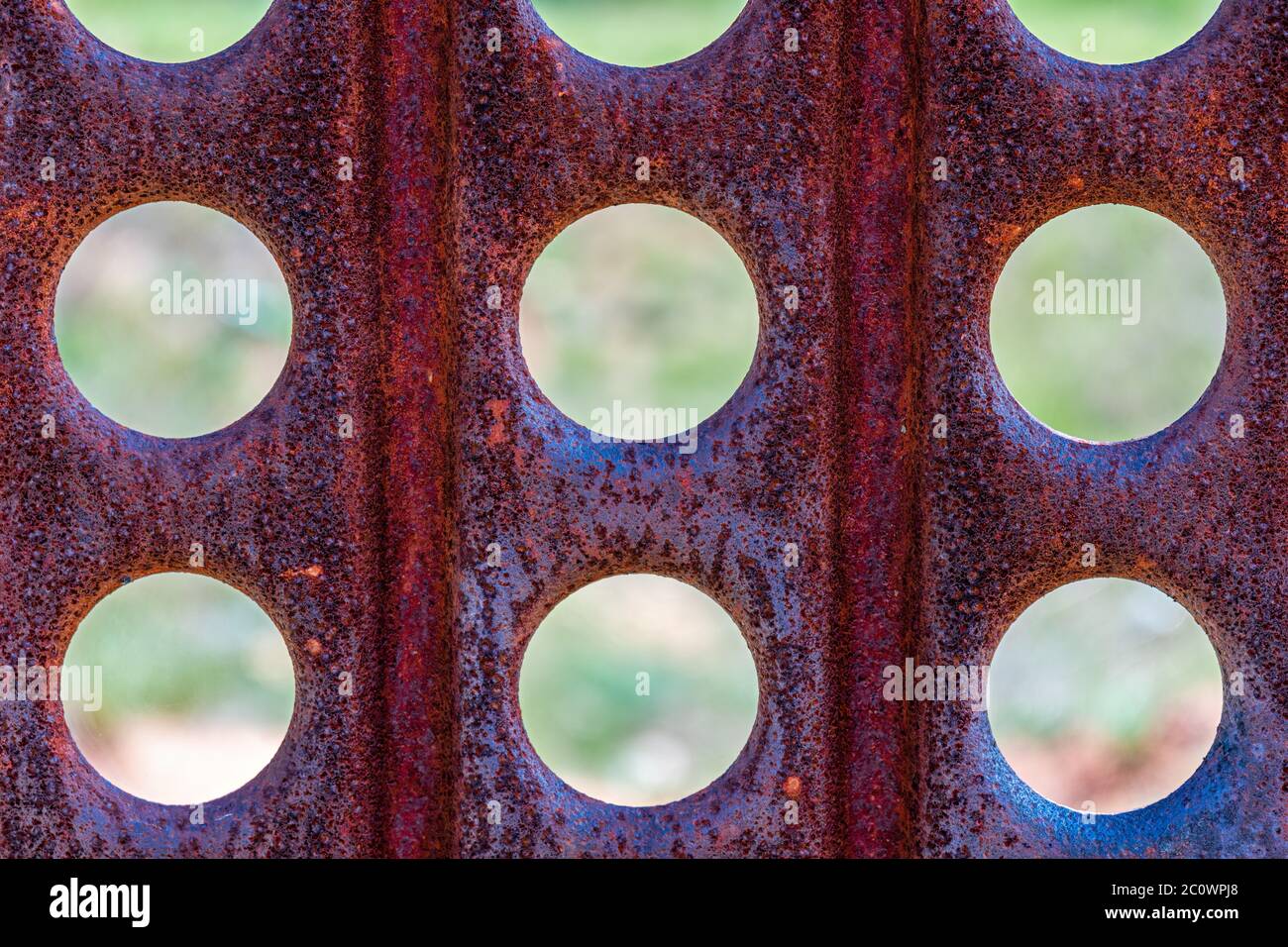 Textur aus altem rostigen perforierten Metall. Runde Löcher in einer Metallblechaufnahme. Abstrakter Bohrungshintergrund. Stockfoto
