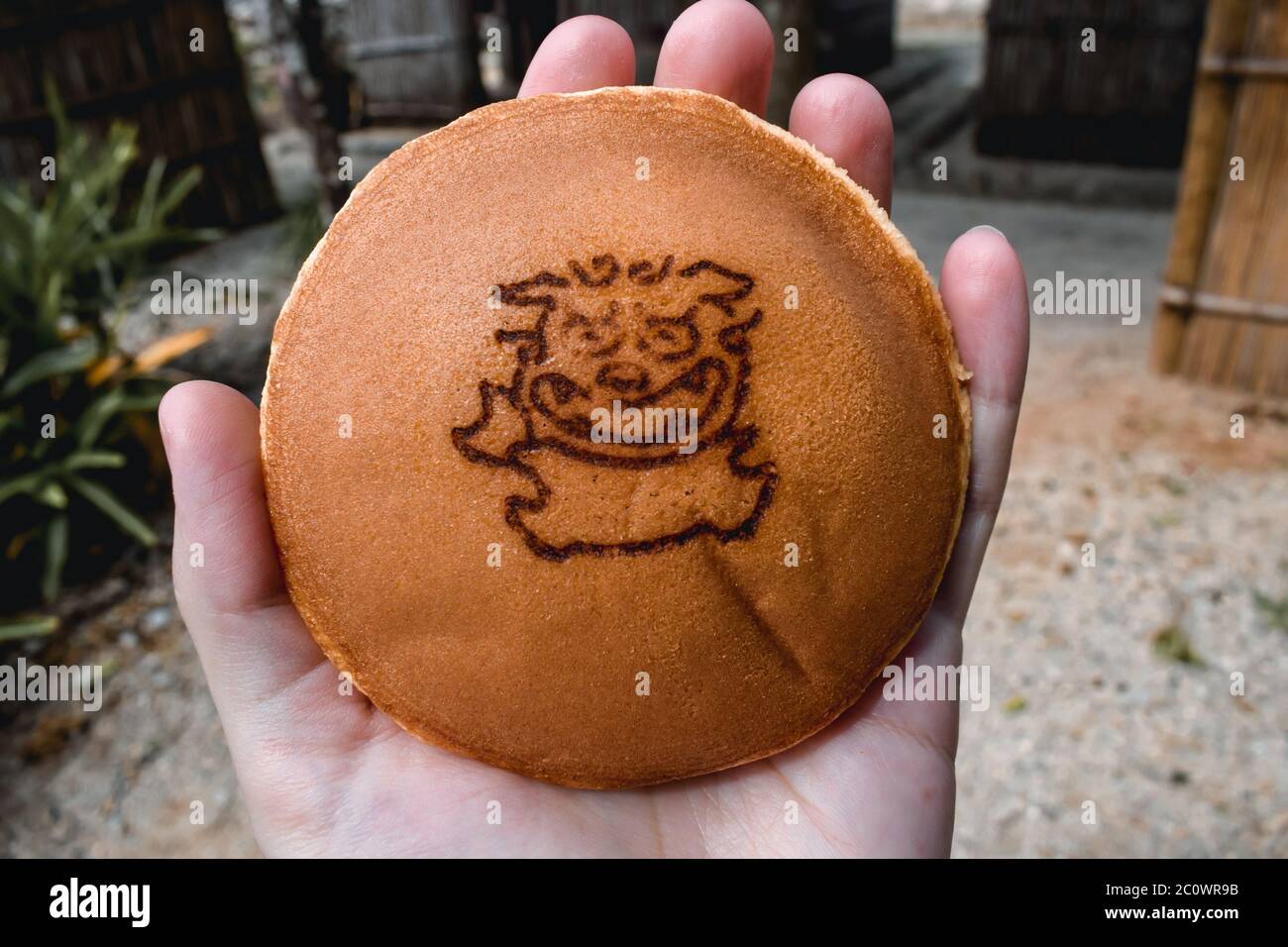 Japanischer Pfannkuchen-Snack mit einem Symbol des mythischen Okinawa-Hundes Shisa Stockfoto