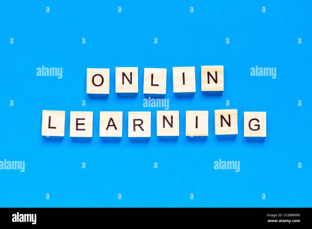 Online-Lernkonzepte in Holzbuchstaben auf blauem Hintergrund geschrieben. Draufsicht auf ein flaches Layout, Online-Schule. Eine neue Form des Lernens Stockfoto