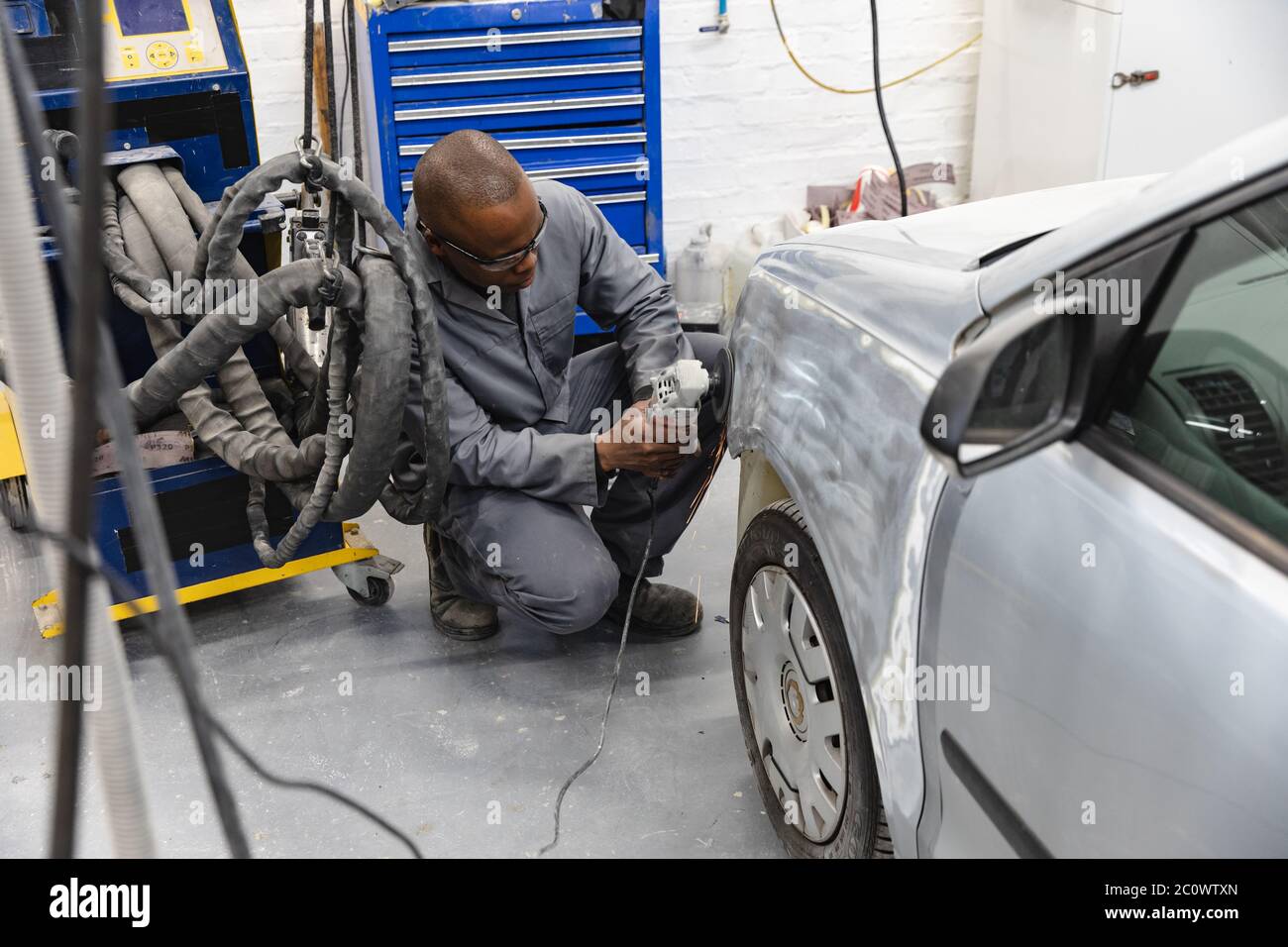 Afroamerikanischer Mechaniker Mann, der ein Auto schleift Stockfoto