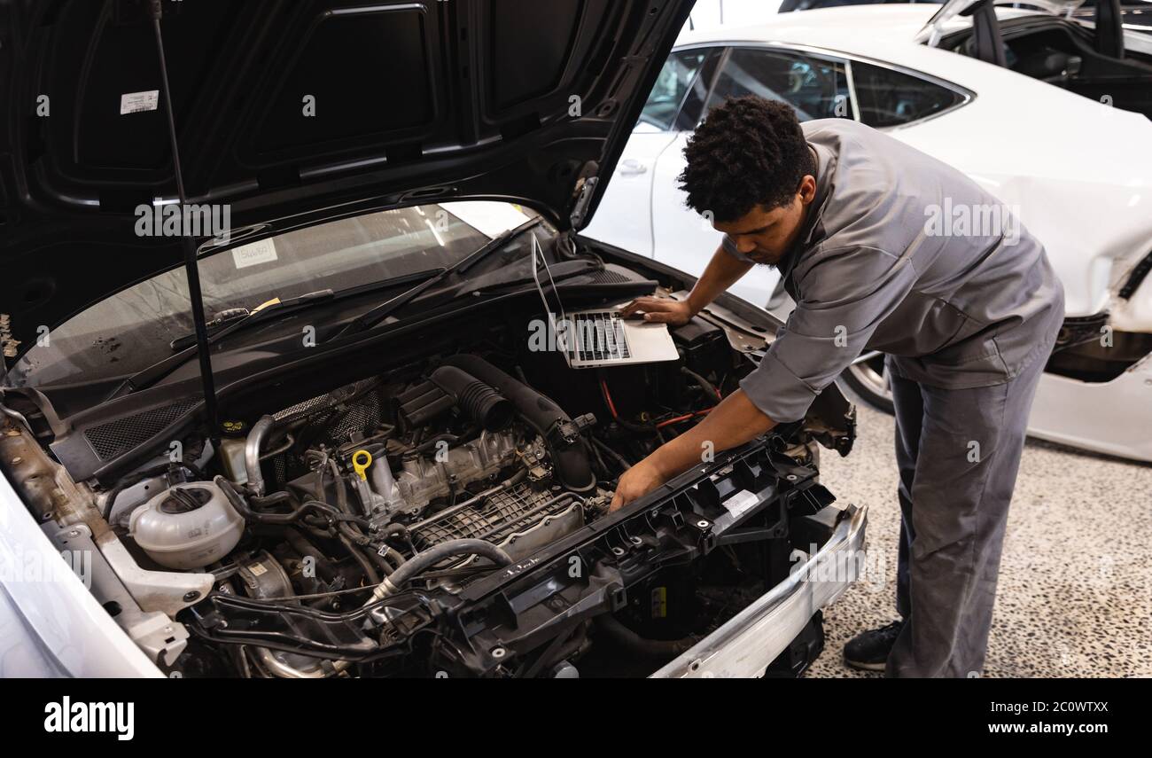 Gemischter Rennmechaniker Mann Inspektion Auto Motor Stockfoto