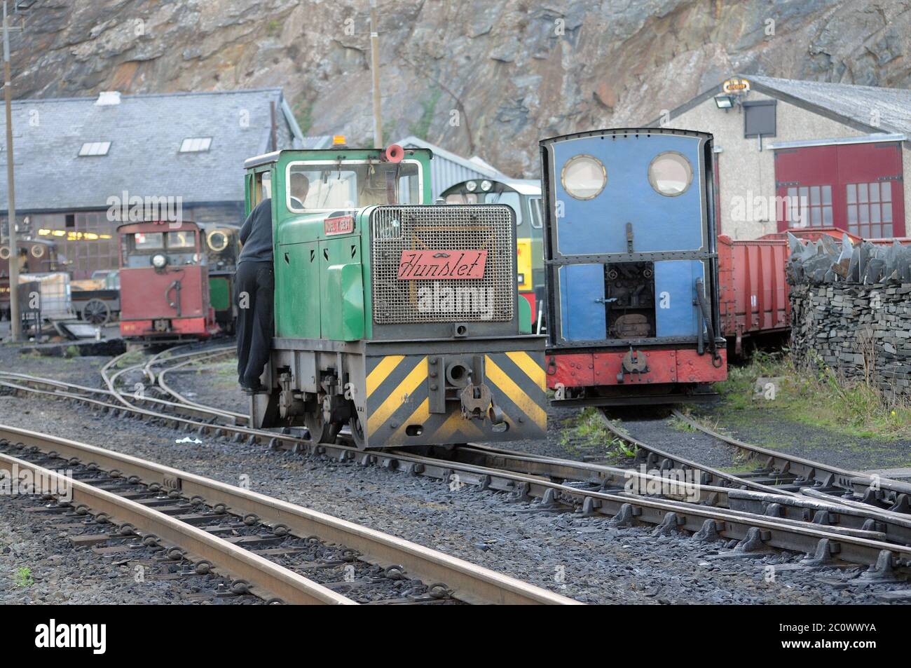 4WD 'moel Y gest' in der Boston Lodge, mit 'Britomart' und 'Vale of Ffestiniog' im Hintergrund. Ffestiniog Railway. Stockfoto