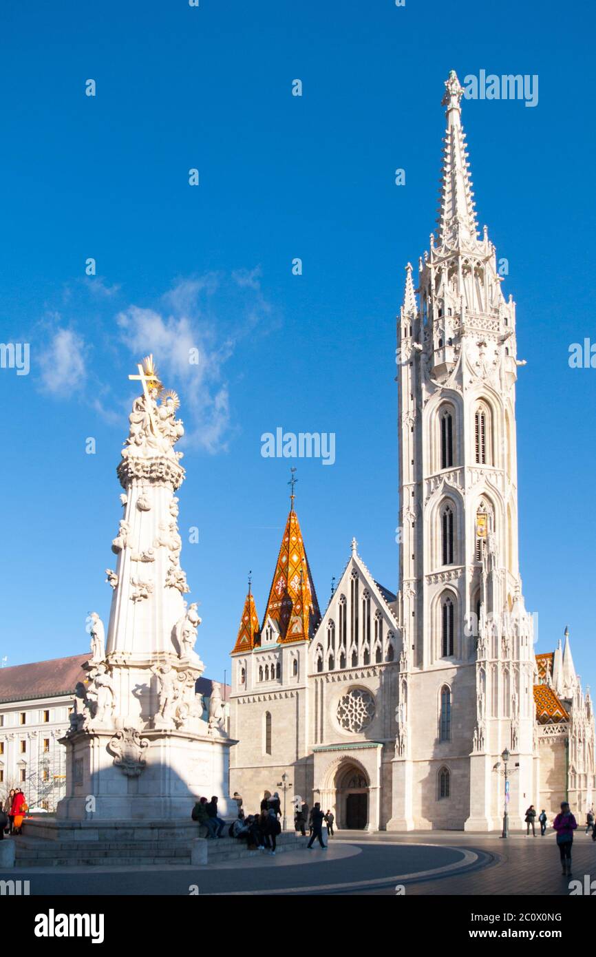 Römisch-katholische Matthias-Kirche und Heilige Dreifaltigkeit Plakette Säule in Fisherman's Bastion in Buda Castle District, Budapest, Ungarn, Europa. Sonniger Tagesfoto mit klarem blauen Himmel. Stockfoto