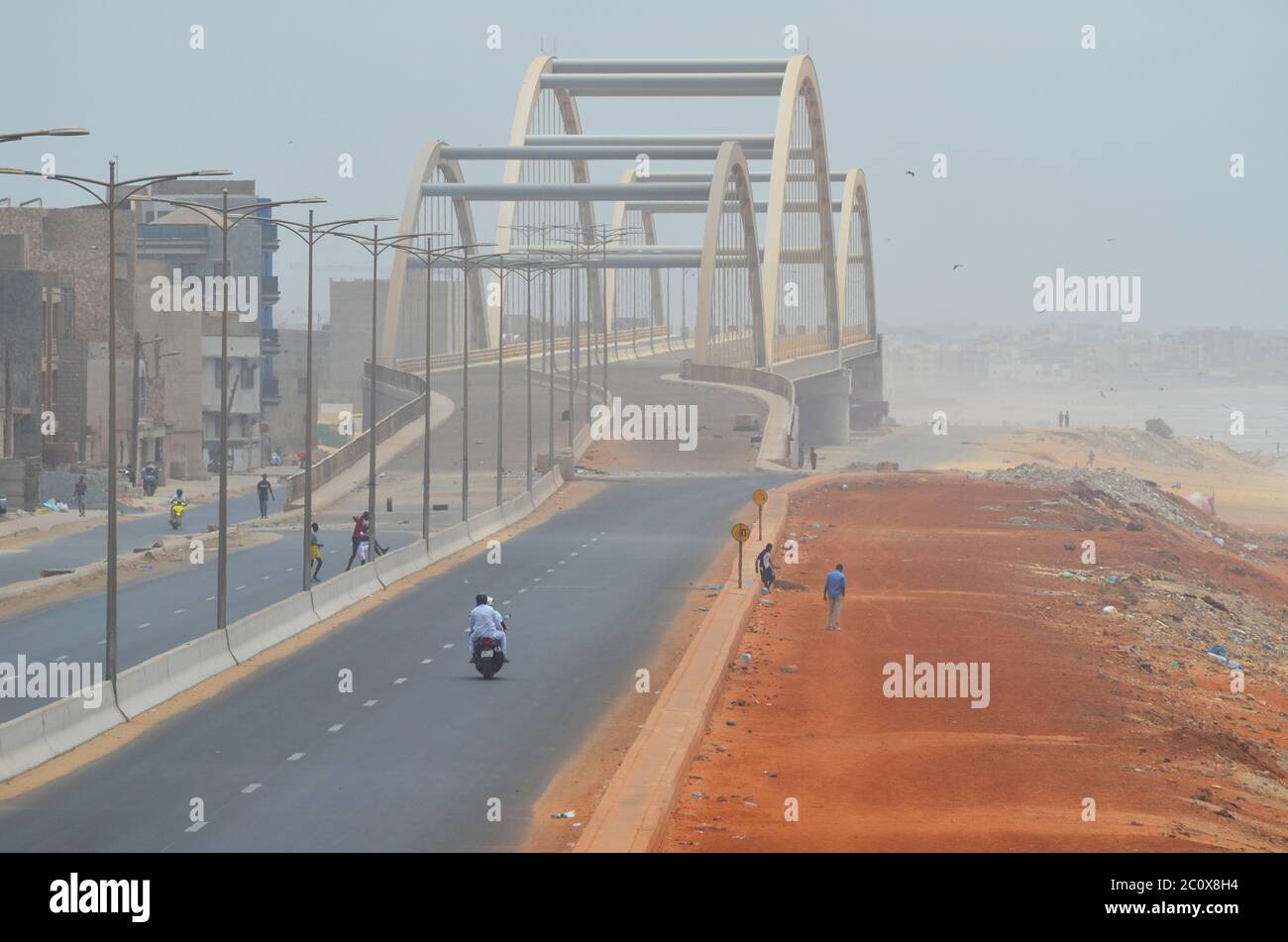 Fast leere Küstenstraße und ebenso leerer Strand im Viertel Guediawaye, Dakar, Senegal Stockfoto