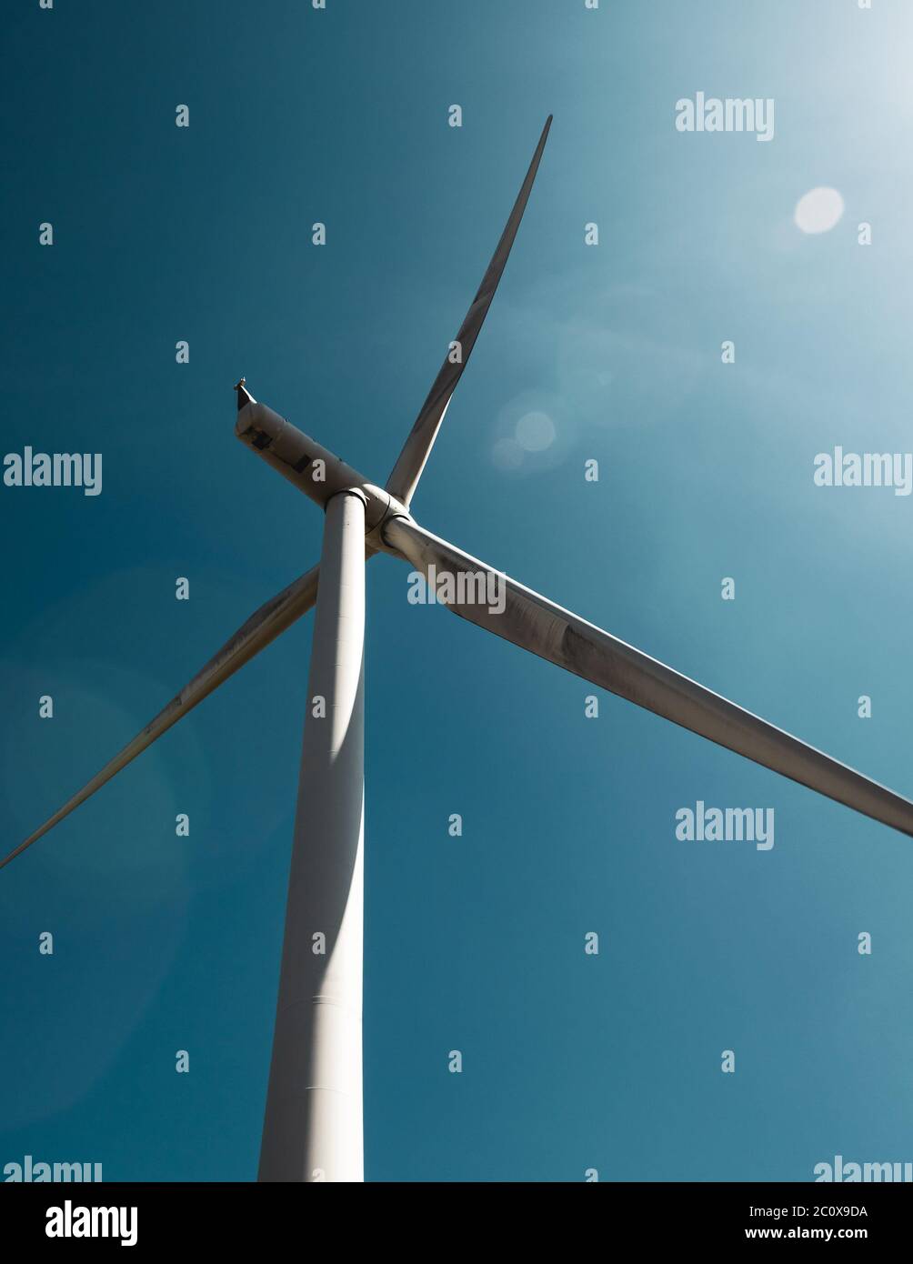 Windturbine auf Whitelee Windpark, Schottland, gegen tiefblauen Himmel mit Sonneneinbrüchen. Stockfoto