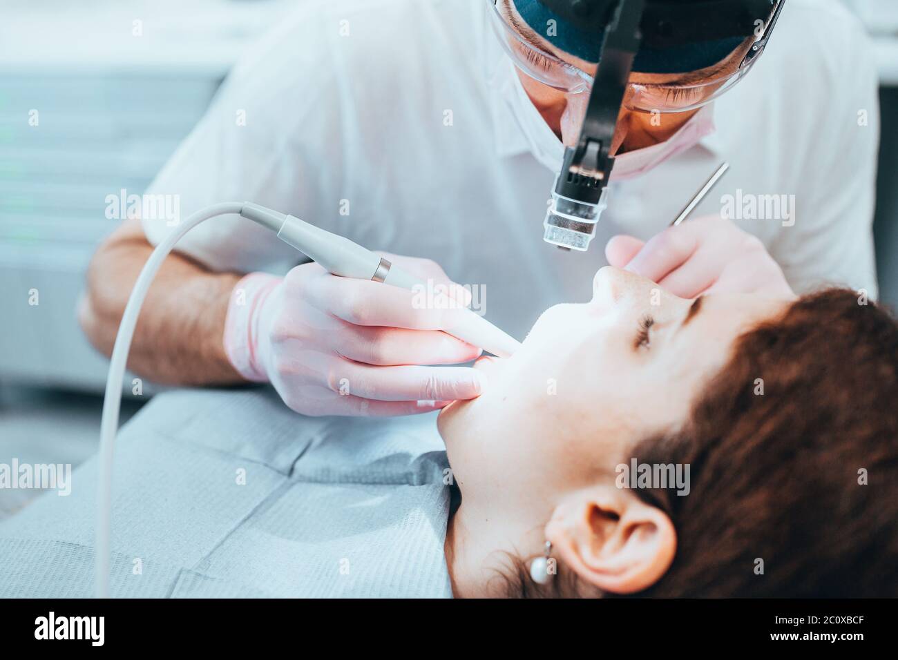 Zahnfüllung - Zahnarzt bereitet einen kranken Zahn - Nahaufnahme des Kopfes Licht Stockfoto