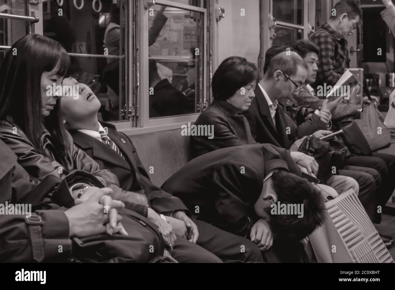 Passagiere müde von der Arbeit schlafen in einem späten Nachtzug in Hiroshima Japan Stockfoto