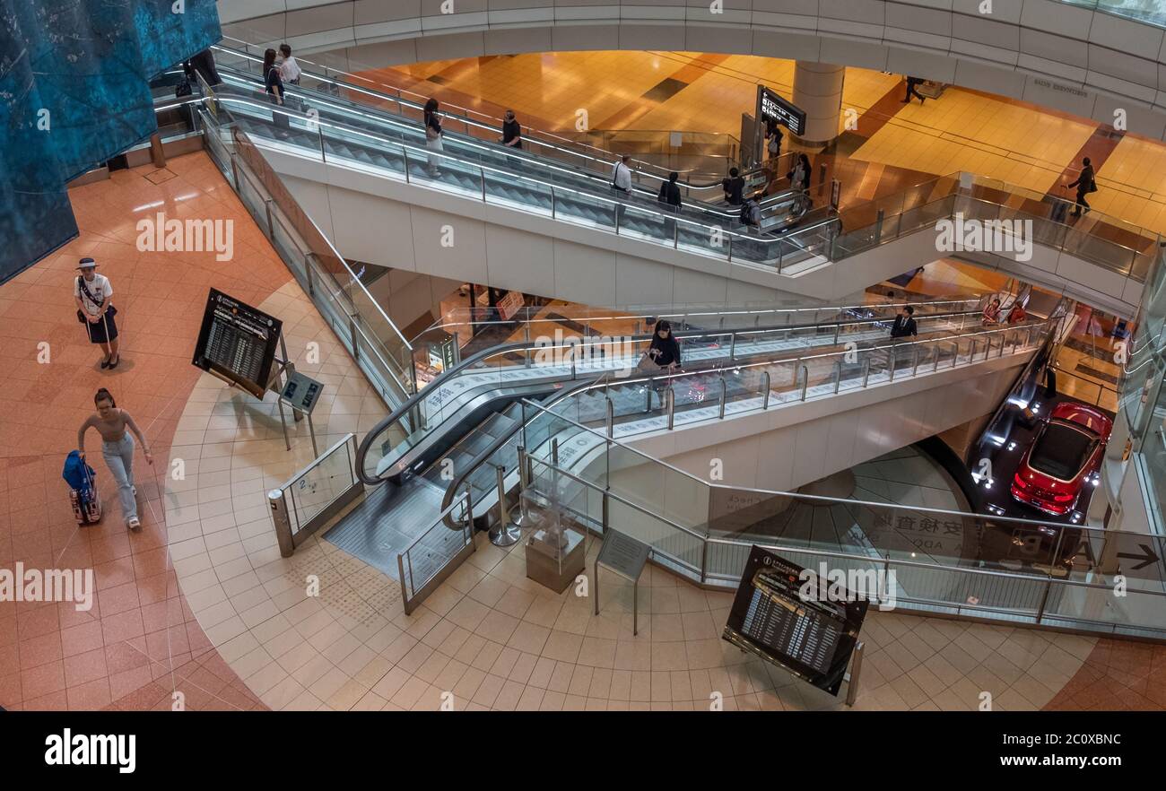 Passagiere, die mit der Rolltreppe am Internationalen Flughafen Haneda, Tokio, Japan fahren Stockfoto