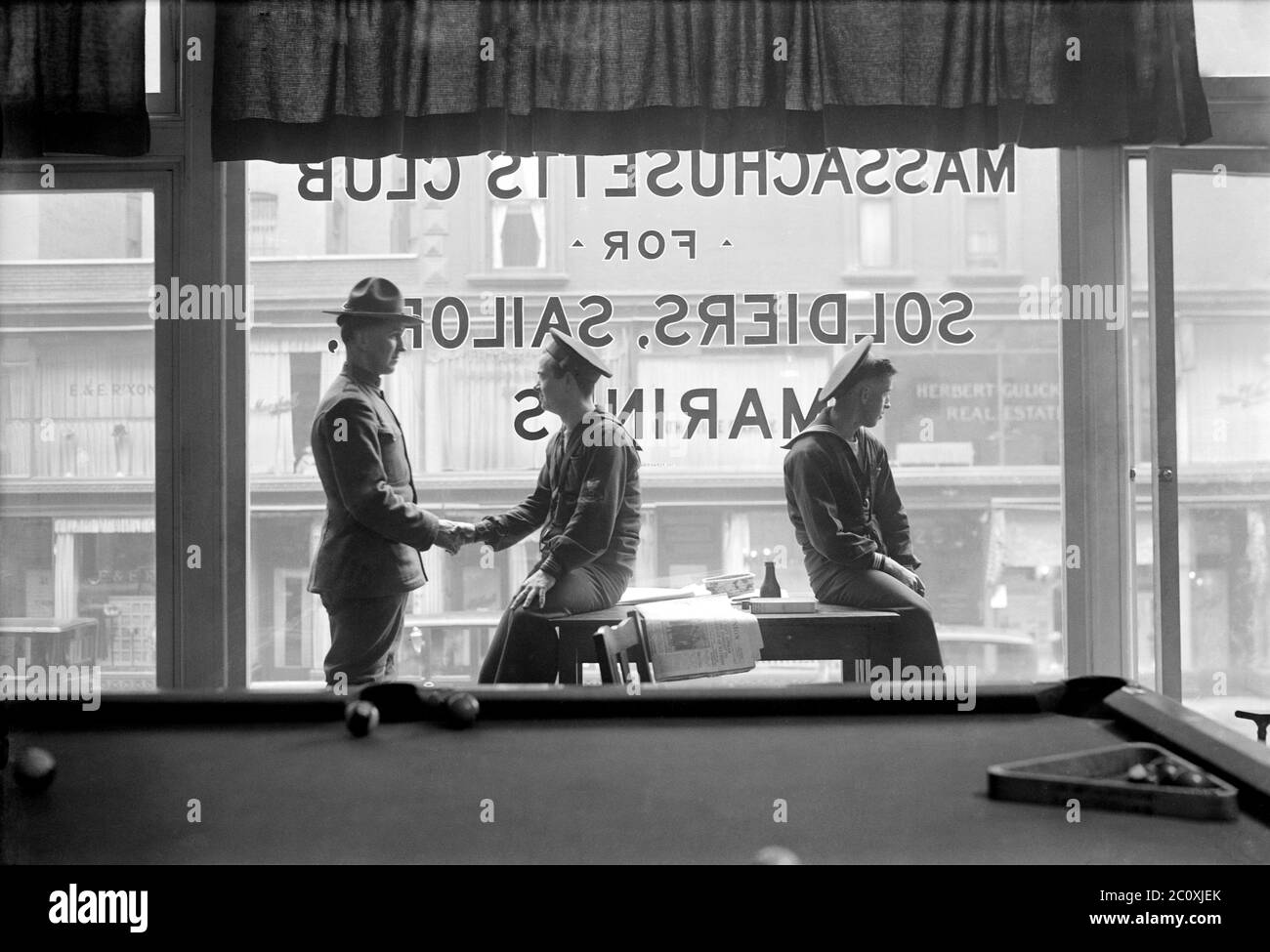 Soldaten und Matrosen sitzen vor dem Fenster mit der Lesung "Kassachesetts Club for Soldiers, Seemanns, and Marines", East 48th Street, New York City, New York, USA, Bain News Service, 1920 Stockfoto
