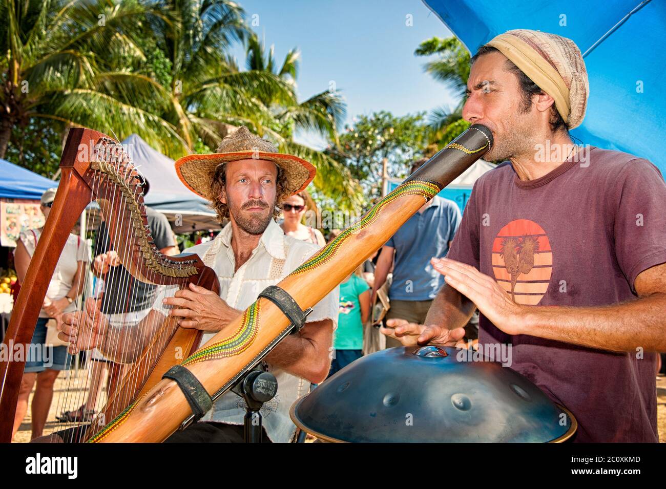 Ein paar Busfahrer mit Harp und Didgeridoo erfreuen die Massen auf den Port Douglas Outdoor Märkten in Far North Queensland in Australien. Stockfoto