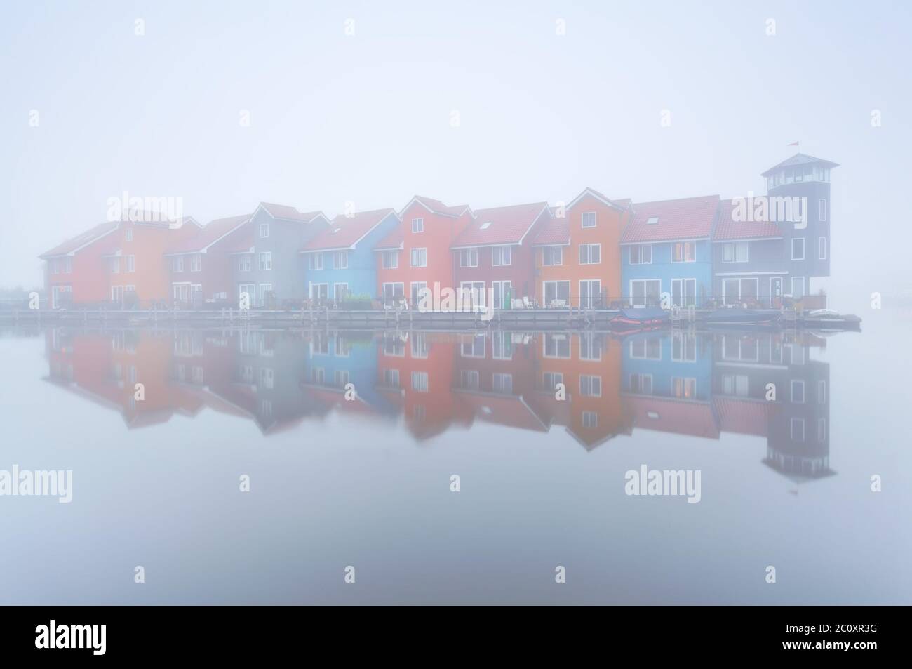 Bunte Gebäude auf Wasser im dichten Nebel Stockfoto
