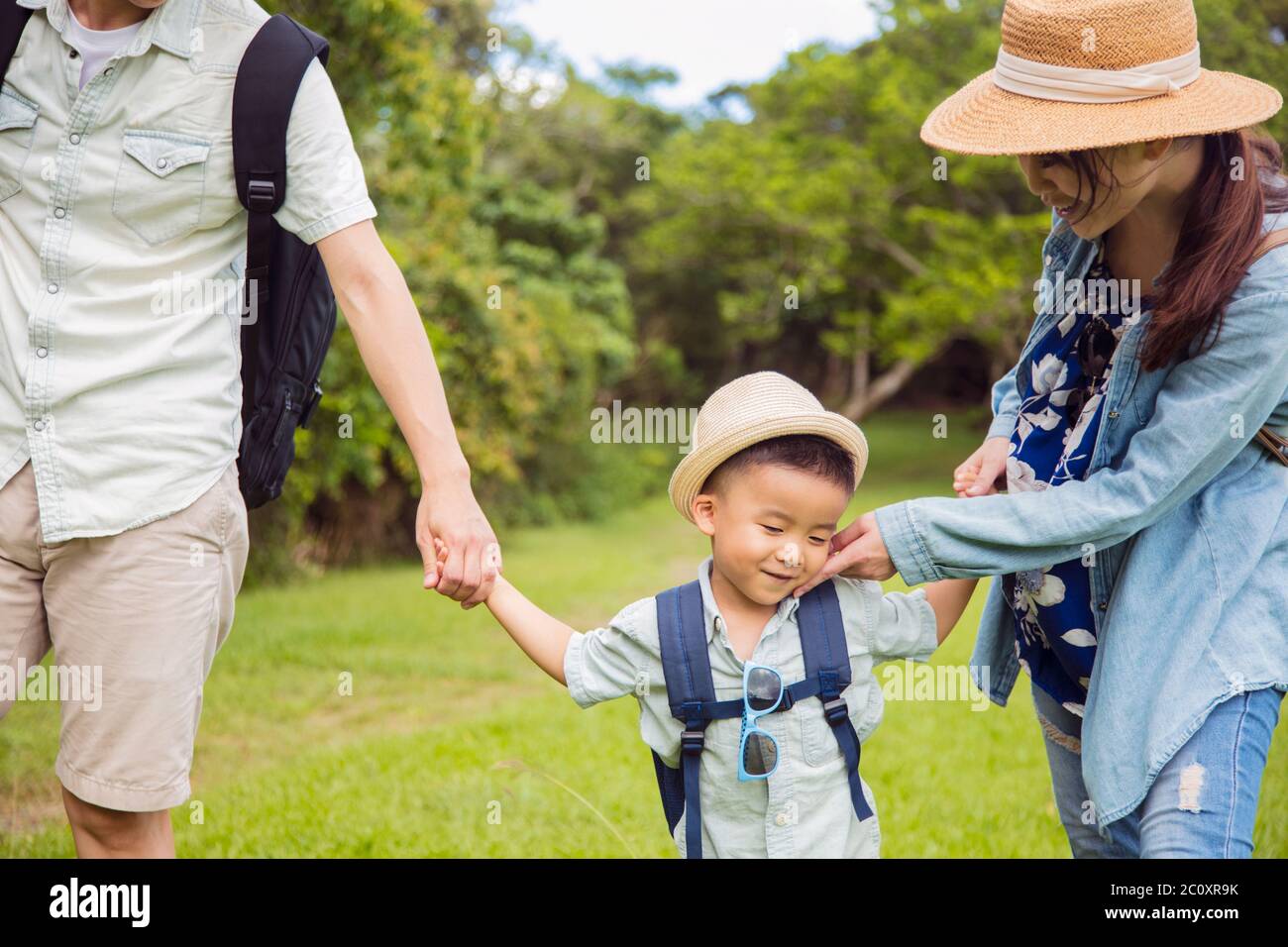 Schüchterner Junge und Eltern wandern im Park Stockfoto