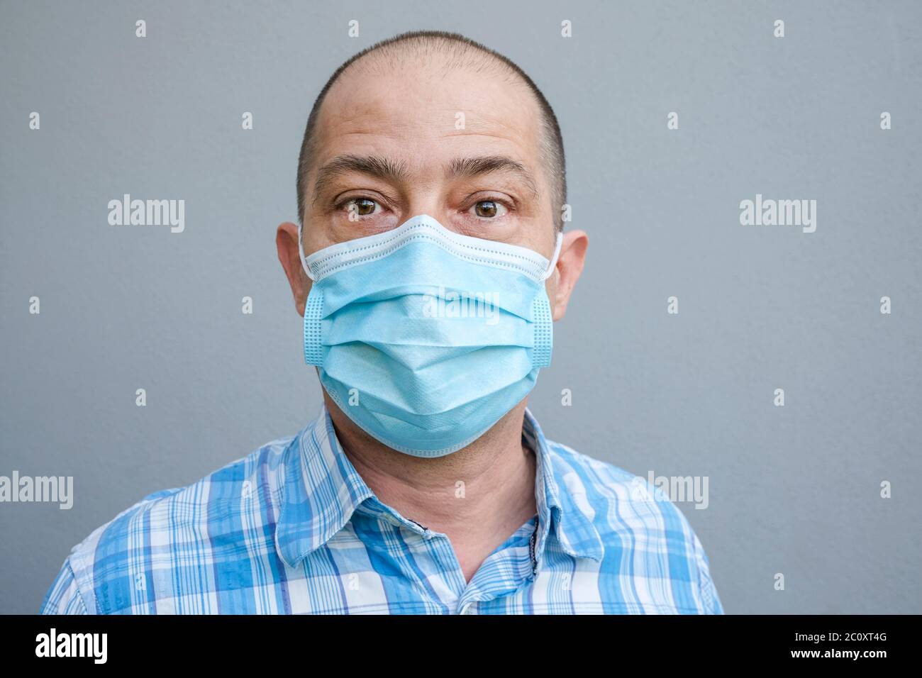 Mann trägt eine chirurgische Gesichtsmaske zur Prävention von Pandemie-Infektion Stockfoto