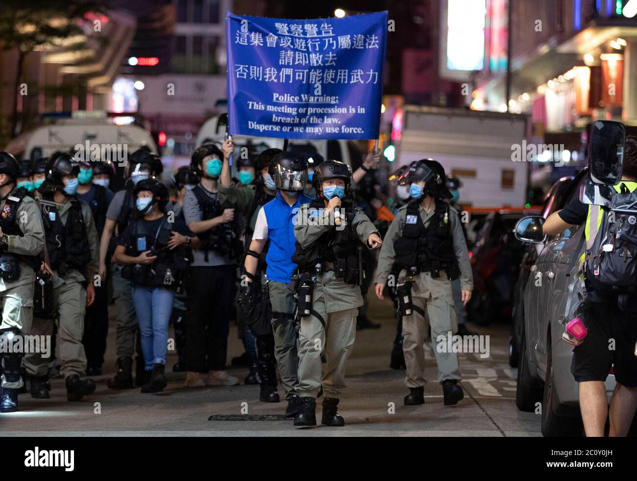 Die Bereitschaftspolizei hält eine blaue Flagge, um die Demonstranten während der Demonstration zu warnen.Tausende von Hongkongern sangen am 12. Juni Protesthymne und skandierten Parolen in der Stadt, als sie den einjährigen Jahrestag der großen Zusammenstöße zwischen Polizei und demokratischen Demonstranten ansprachen. Stockfoto