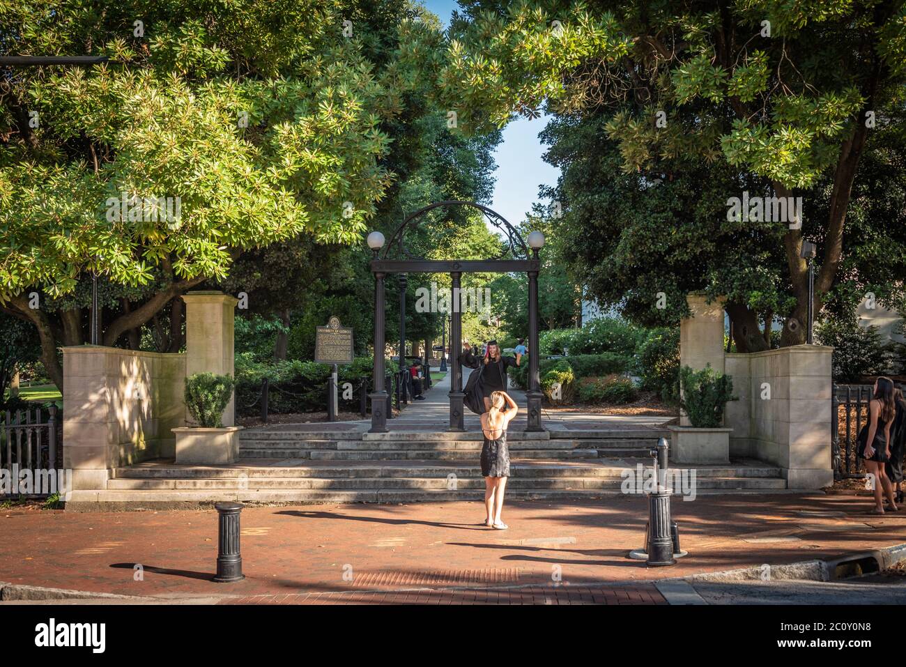 Der Senior wird für ein Foto unter dem berühmten Wahrzeichen Arch an der Universität von Georgia in der Innenstadt von Athen, Georgia, geposiert. (USA) Stockfoto