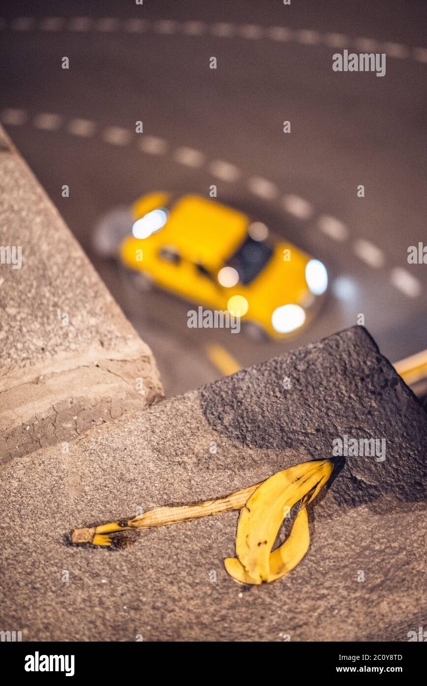 gelbes Taxi Taxi vorbei Ecke auf den unscharfen Hintergrund mit Bananenschale vor Stockfoto