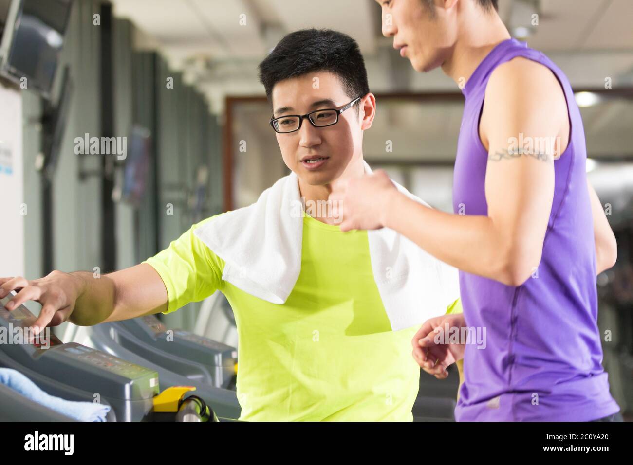 Junge asiatische Männer und trainieren Sie im modernen Fitnessraum Stockfoto