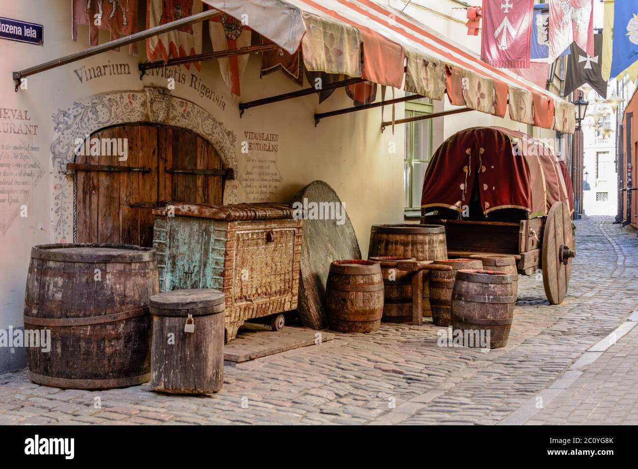 Mittelalterwagen, Holzfässer und schwere Truhe in der Nähe mittelalterlicher Restaurant in der Altstadt. Stockfoto