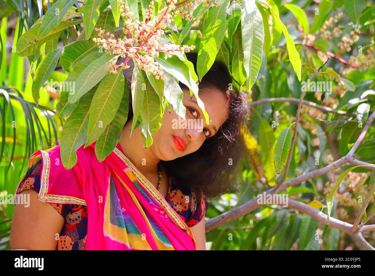 Portrait Bild von einem schönen jungen Mädchen aus Mangogrün Blätter Hintergrund und Blick auf die Kamera, Konzepte für Frauen Heide Pflege Stockfoto