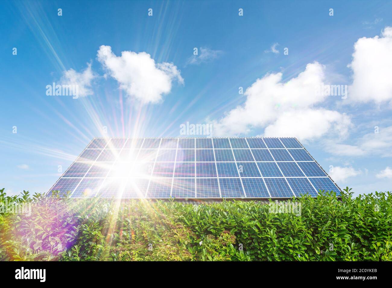 Haus mit Sonnenkollektoren auf dem Dach und landschaftlich schönen Sonnenstrahlen Stockfoto