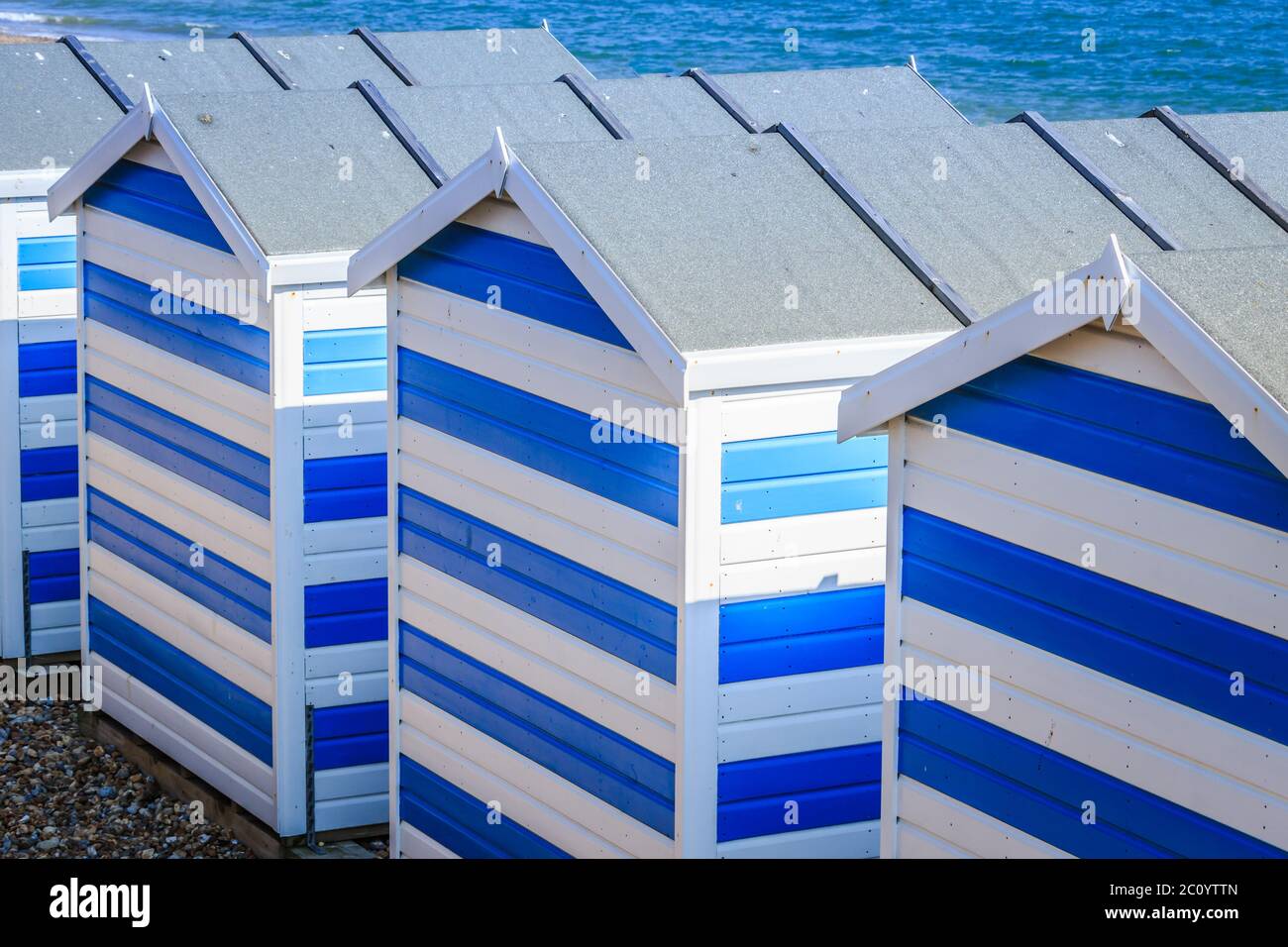 Blau-weiße Strandhütten am Meer in Hasting's UK, auf dem Ärmelkanal. Stockfoto