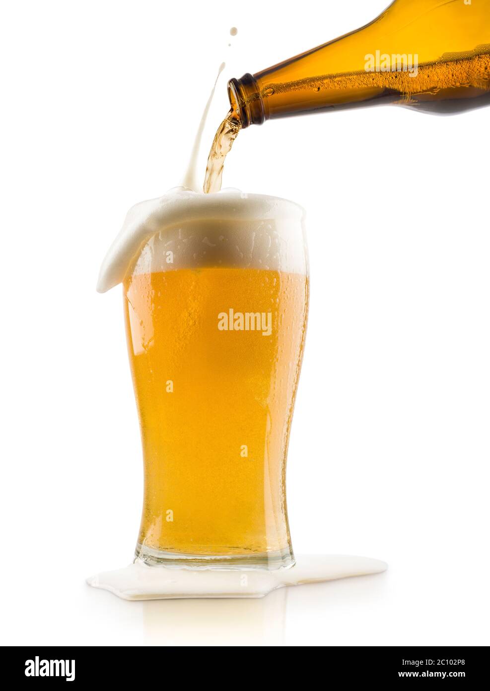 Blondes Bier mit Spritzschaum in Glas gießen, auf weißem Hintergrund Stockfoto