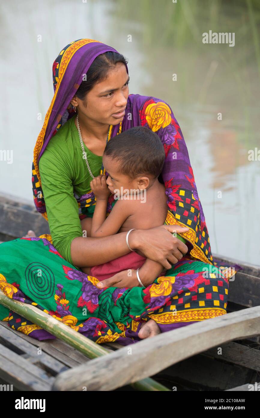 Mutter füttert ihr Kind auf dem Boot in der von Überschwemmungen betroffenen Region von Bangladesch Stockfoto