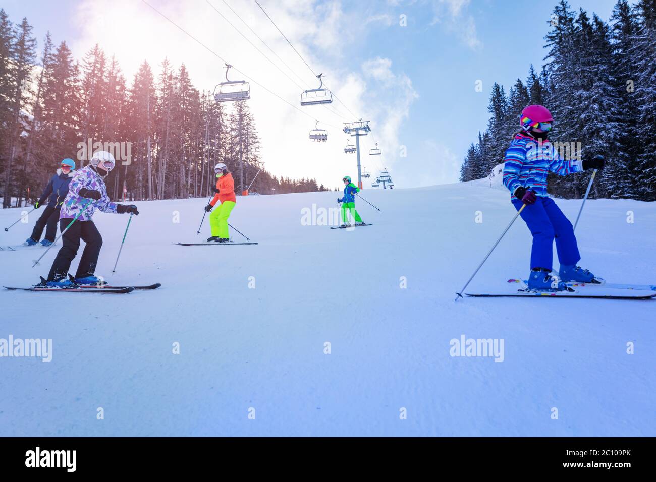 Gruppe von Teenagers Kinder Ski Downhill zusammen in den Berg mit Sessellift auf dem Hintergrund Stockfoto