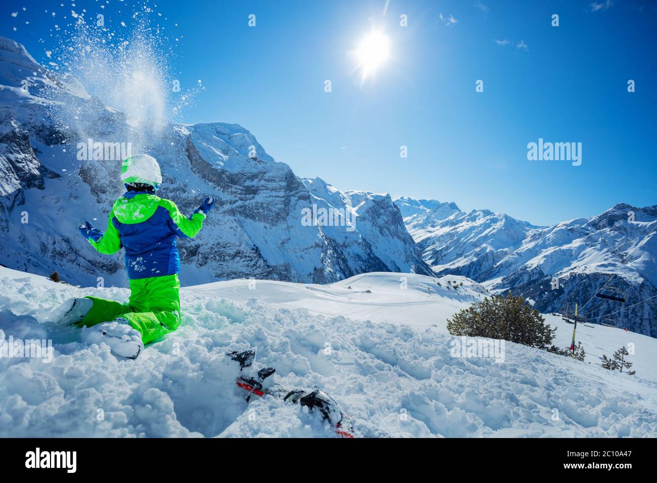 Portrait von niedlichen Kind sitzen Ruhe nach Skifahren im Schnee über sonnigen Bergpanorama Kopierraum Stockfoto